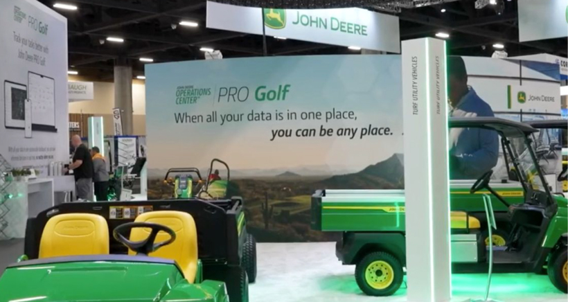 John Deere booth at a tradeshow with a background banner saying, "PRO golf, when all your data is in one place, you can be any place"